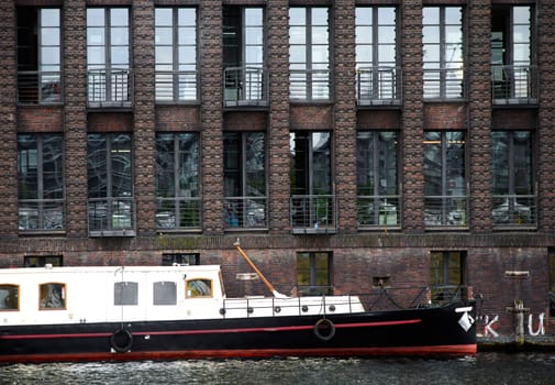 The photograph of an old brick building with offices on the Spree in Berlin.
