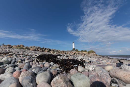 Lighthouse of Langeland behind rocky beach of the Baltic Sea