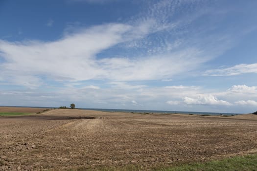 Large empty field with the Baltic Sea in the background