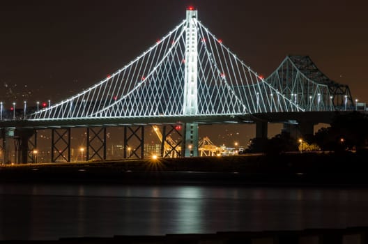 A night view of Bay Bridge in San Francisco, California, United States of America. A bridge suspended by cables over the Frisco Bay connecting San Fran to Oakland and through Treasure Island.