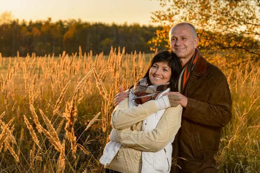 Romantic couple hugging enjoy autumn sunset countryside looking away
