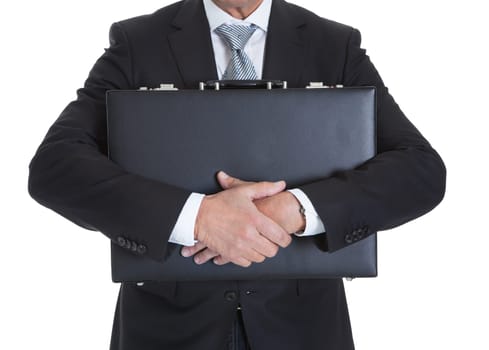 Close-up Of Businessman Holding Briefcase Over White Background
