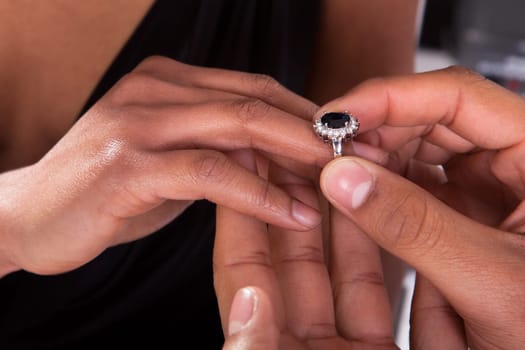 Close Up Of Male Hand Inserting An Engagement Ring Into A Finger