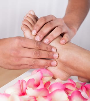 Close-up Of Hand Massaging Foot In Spa