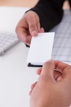 Close-up Of Business Hands Giving Visiting Card To Partner