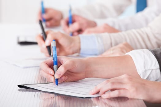 Business People Sitting In A Row And Writing Notes In Office