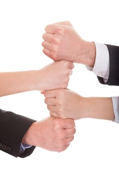 Close-up Of Businesspeople Hands Stacking Together Over White Background