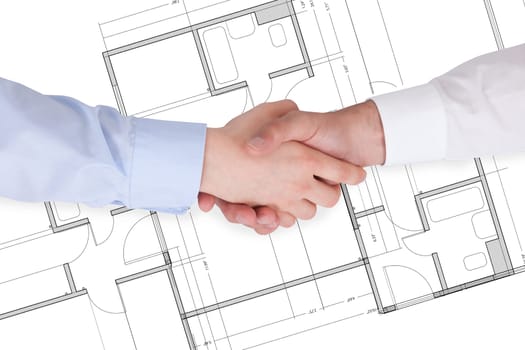 Close Up Of Two Businesspeople Shaking Hands Over Blueprint