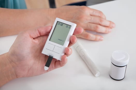 Close-up Of Hand Holding Sugar Level Checking Machine