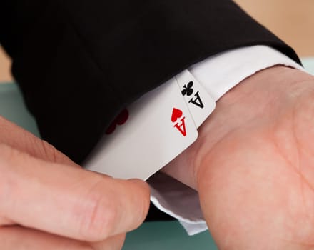 Close-up of a man's hand removing ace from sleeves