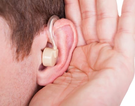 Close-up Ear Of A Man Wearing Hearing Aid And Listening For A Quiet Sound