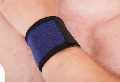Close Up Of Man Wearing Wrist Band In Hand Over White Background