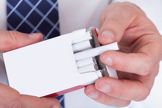 Close-up Of Man Hand Taking Cigarette  From Packet