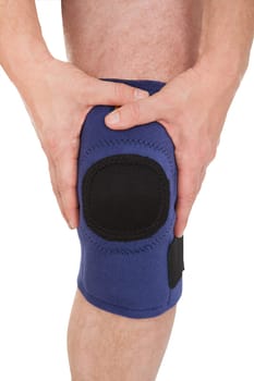Close-up Of A Man Wearing Knee Brace Over White Background