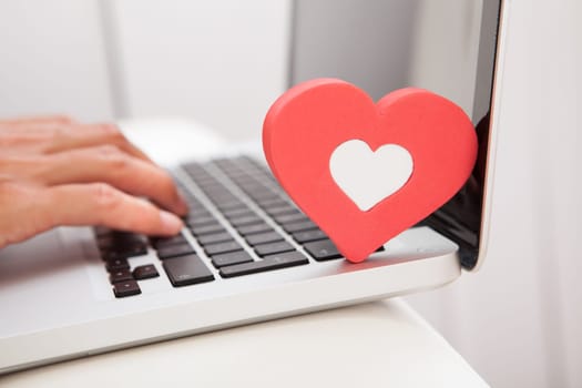 Young Happy Woman Showing Heart Shape While Using Laptop On Couch