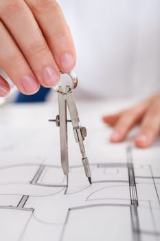 Closeup cropped image of a young male architect working on blueprints spread out on a table