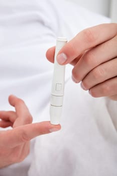 Close-up Of Man Examining Blood Sugar Level Of His Own