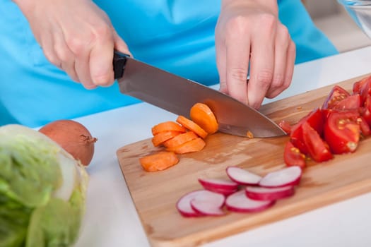 Cheerful young woman cooking in the kitchen