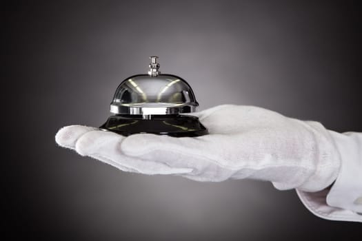 Close-up Of Hand With White Gloves Holding Service Bell