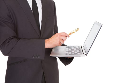 Close-up Of Businessman Looking At Laptop Through Magnifying Glass
