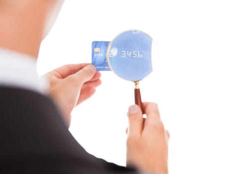 Close-up Of Man Looking At Credit Card Through Magnifying Glass On White Background