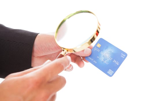 Close-up Of Man Looking At Credit Card Through Magnifying Glass On White Background