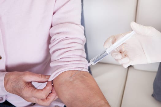 Young Female Doctor Injecting Vaccine To Senior Woman  Indoor