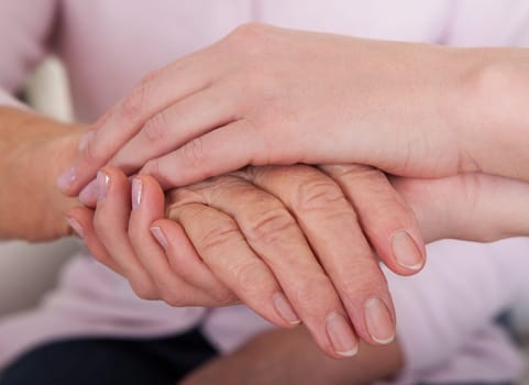 Young Woman Holding Senior Woman's Hand  Indoor