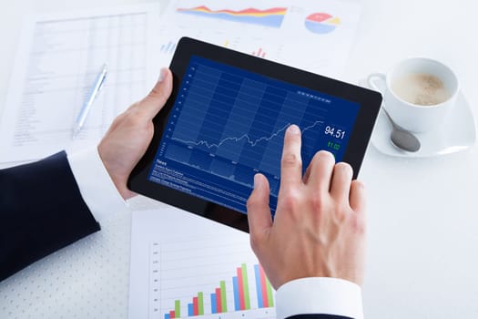 Businessman Analyzing Graph On Digital Tablet In Office