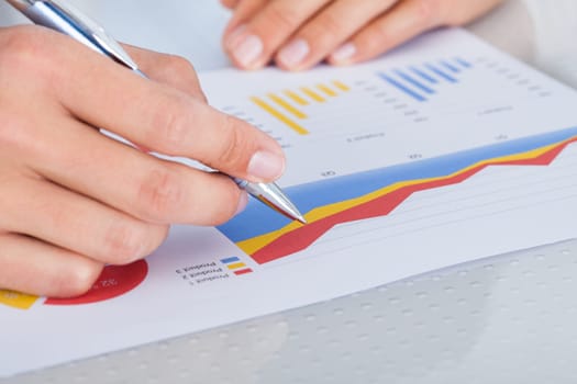 Close-up Of A Businessman Writing On Graph Printed On Paper