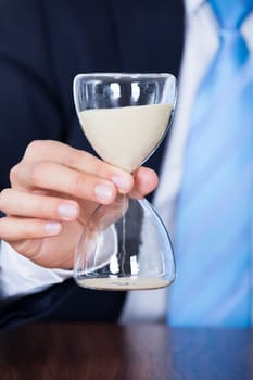 Close-up Of Businessman's Hand Holding A Hourglass