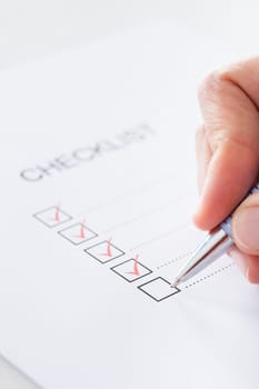 Close-up Of Human Hand Filling Check Boxes On Form