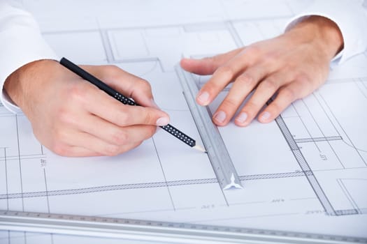 Close-up Of Male Architect Working On Blueprint At Desk
