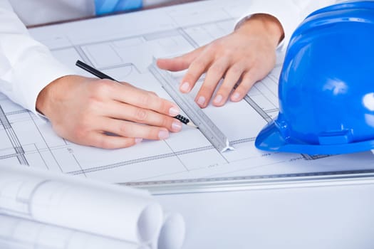Close-up Of Male Architect Working On Blueprint At Desk