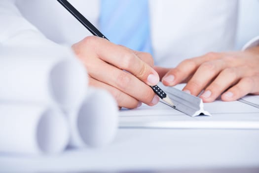 Close-up Of Male Architect Working On Blueprint At Desk