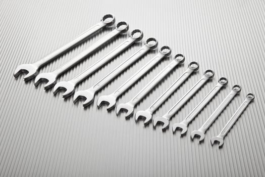 Metallic wrench tool set on metal background