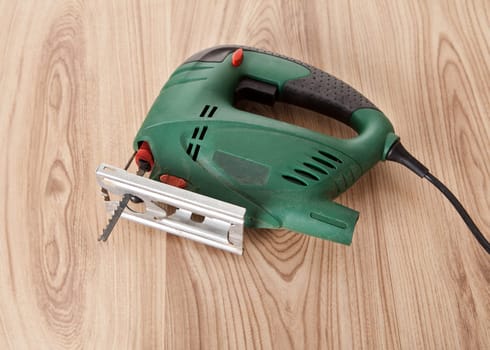 Electric jig saw lying on wooden table