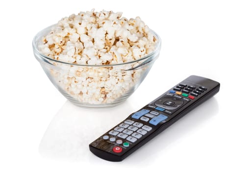 Close-up Of Remote Control And Bowl Of Popcorn Over White Background