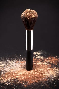 Makeup Brush And Cosmetic Powder Isolated On Black Background