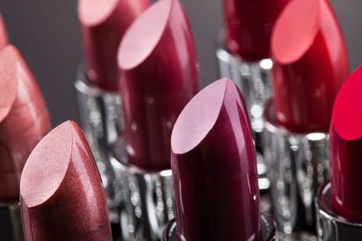 Lipsticks In A Row Isolated Over Gray Background