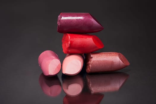 Close-up Of Lipsticks Over Black Reflective Background