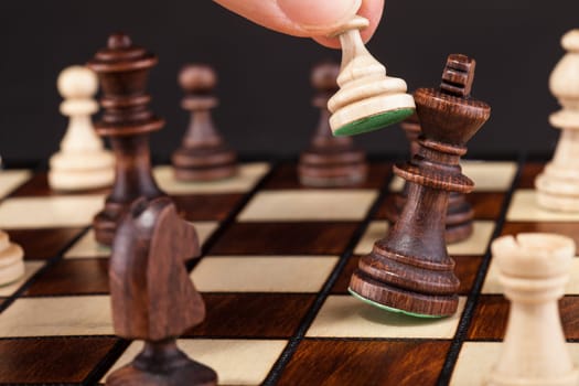 Close-up Of Hand Playing Chess And Falling King