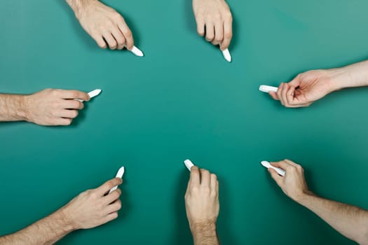 Hand holding chalk writing on green blackboard