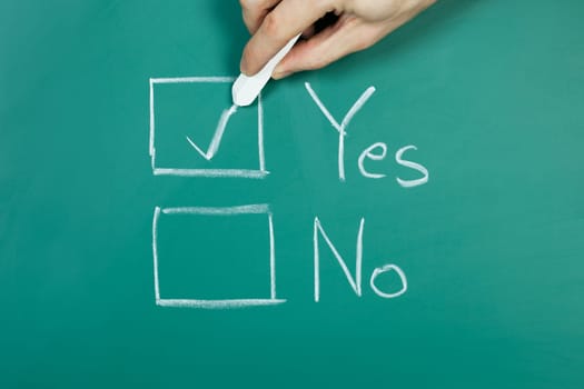 Hand holding chalk making a yes choice