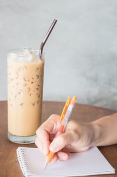 Hand writing on note paper in coffee shop, stock photo