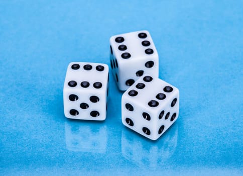 Three White Dice For Gambling Over Blue Background