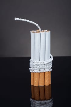 Cigarettes Tied With Rope And Wick Over Blue Background