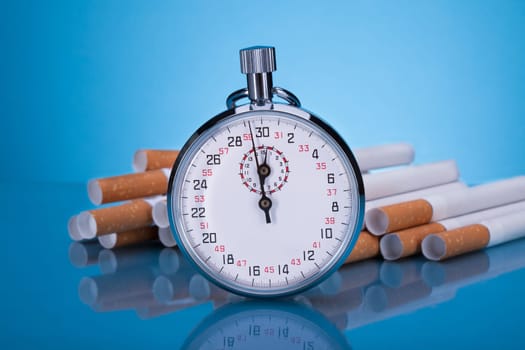 Photo Of Stopwatch And Cigarettes On Gray Background