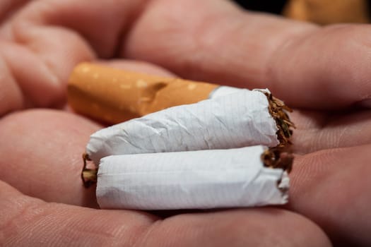 Close-up Shot Of Hand Holding Broken Cigarette