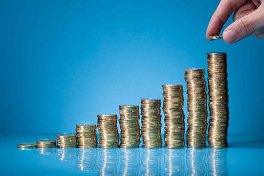 Hand Placing More Money To Growth Chart Of Coins